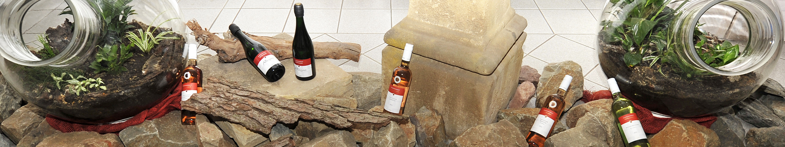 Weinflaschen zwischen Steinen  und Holz dekoriert ©Feuerbach